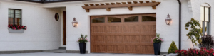brown garage door with windows on white home with trellis